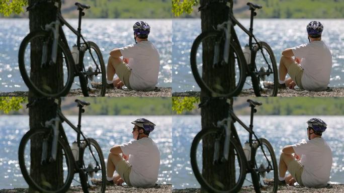 骑自行车的人坐在风景如画的湖边