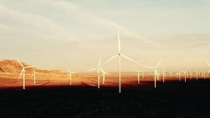 在沙漠中日落时旋转的风力涡轮机的空中轮廓