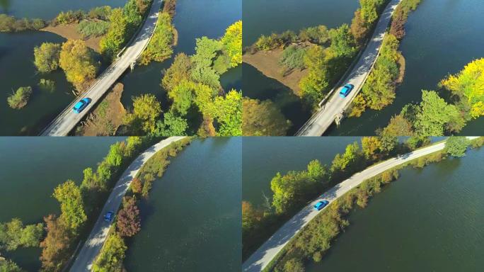 空中: 飞越蓝色汽车驾驶槽在秋天淹没了乡下人的田野