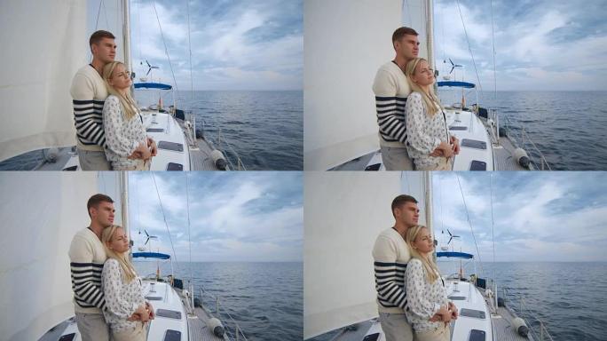 年轻夫妇在海里的帆船上放松。