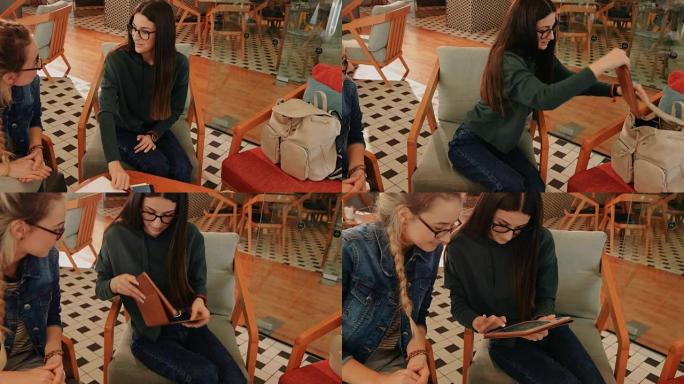 年轻的十几岁的女孩带着平板电脑在咖啡馆上学