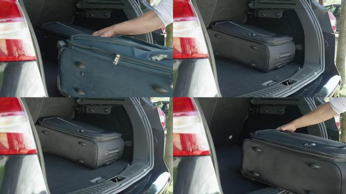 特写: 不知名的男性从他宽敞的汽车后备箱里提着旅行包。