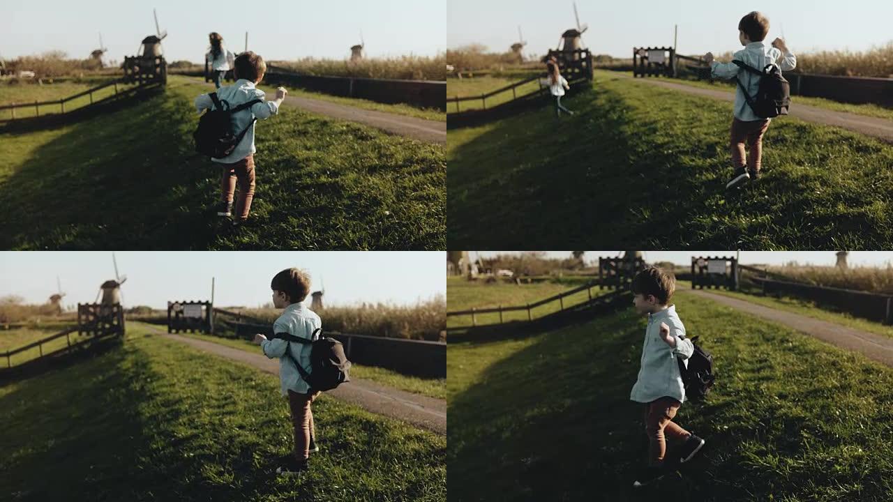 两个小孩在老风车农场附近玩耍。快乐的孩子在乡村风景中奔跑。幸福和快乐。4K