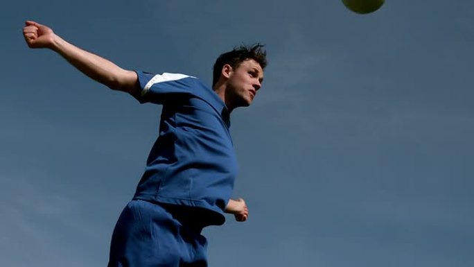 足球运动员在蓝天下头球