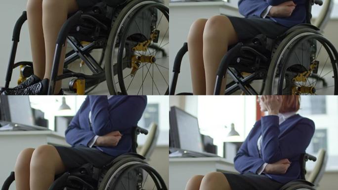 坐在轮椅上的女商人看着桌子上的电脑