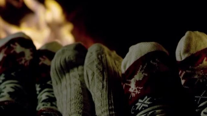 4k舒适的脚穿着圣诞袜，在舒适的壁炉旁放松，慢动作