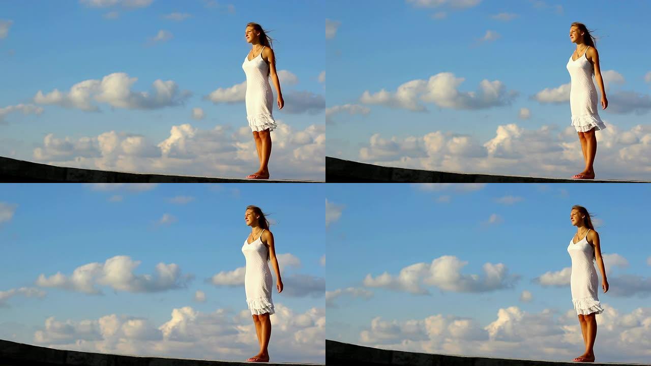 云朵背景下的女孩一个人站在高处年轻少妇清
