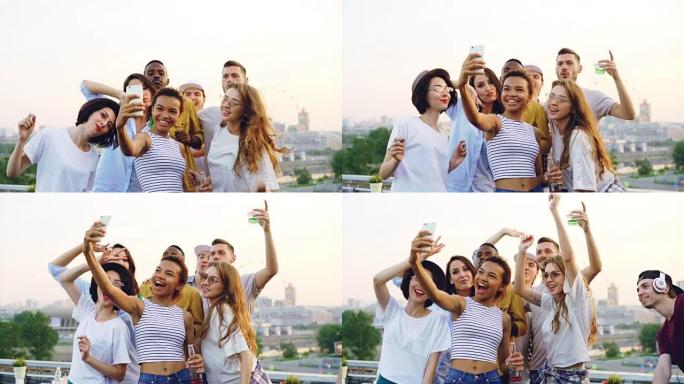 漂亮的非洲裔美国女人的慢动作录制屋顶派对的视频，她的朋友跳舞，看着智能手机摄像头。娱乐、青春和音乐概