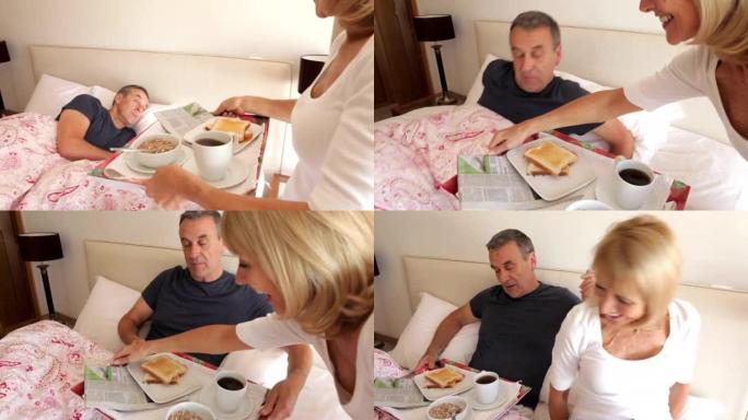 高级妇女在床上带丈夫早餐