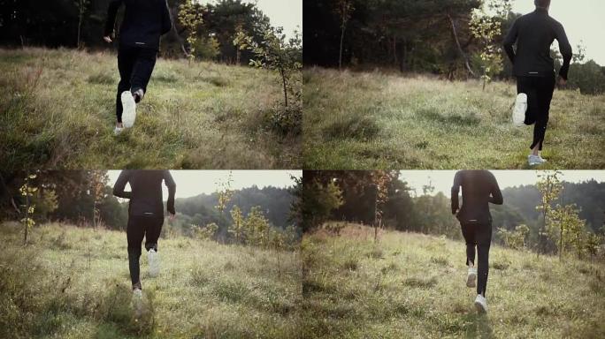 缓慢的运动。一个人跑上高高的草山上。后视图跟踪镜头。镜头跟随越野运动员