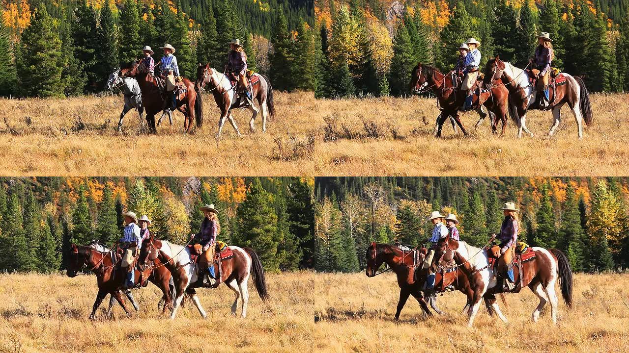 牛仔和两个牛仔女孩骑马穿过山麓