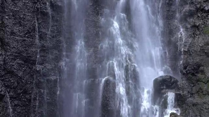 特写: 巨大的雄伟的白水瀑布溅落在岩石墙上