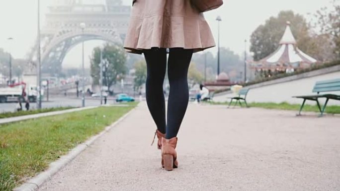 女性脚的特写视图。清晨，年轻时尚的女人走在法国巴黎的埃菲尔铁塔附近
