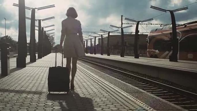 自信的女人带着行李走过火车站的镜头