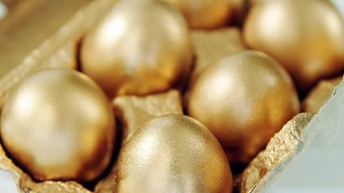 鸡蛋纸箱中的金色复活节彩蛋特写