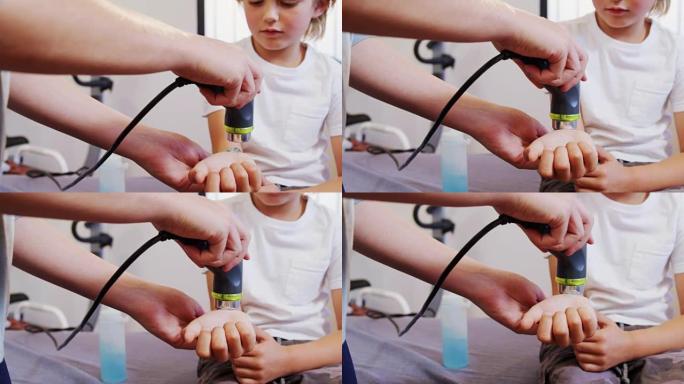 物理治疗师为4k男孩提供手部按摩
