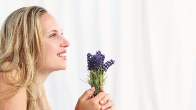 漂亮的金发女人闻到薰衣草