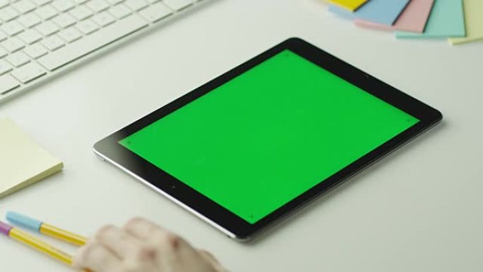设计师正在横向模式下使用带有绿屏的平板电脑。在4k (UHD) 的红色电影相机上拍摄。它易于缩放、旋