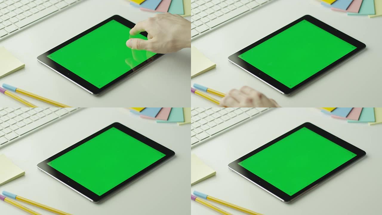 设计师正在横向模式下使用带有绿屏的平板电脑。在4k (UHD) 的红色电影相机上拍摄。它易于缩放、旋