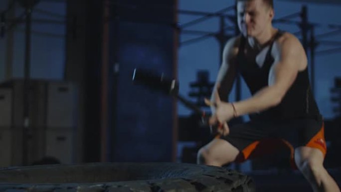 男子在健身房用锤子锻炼身体