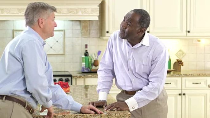 两个多民族的成熟男人在厨房里聊天