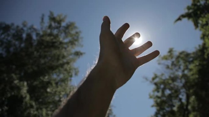 举升到阳光下的手轮廓。在大自然中与太阳交手