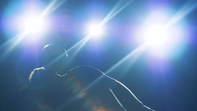 职业足球运动员在明亮的光线下用球顶在头上耍把戏，脸不可见，正面，特写。
