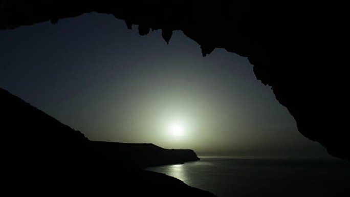 太阳升起在海岸上。从山洞看