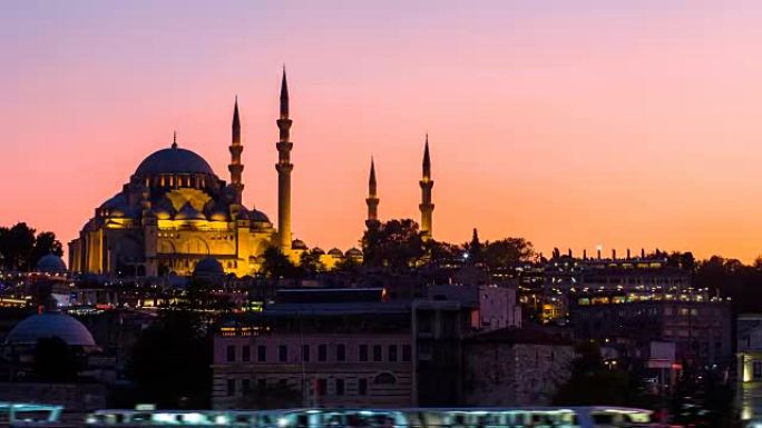 缩小苏莱曼尼耶清真寺的延时视图，旅游船夜间漂浮在伊斯坦布尔的博斯普鲁斯海峡