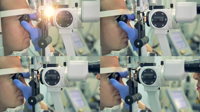 配镜师拿着镜片检查患者的眼睛。