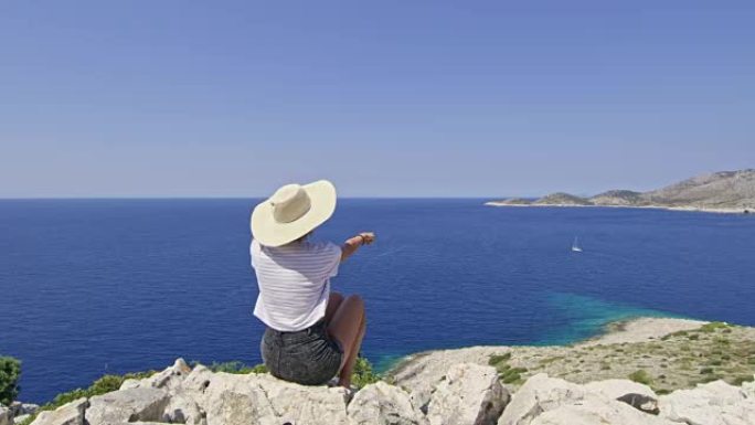 克罗地亚拉斯托沃，欣赏风景秀丽的海景，指着遥远的帆船