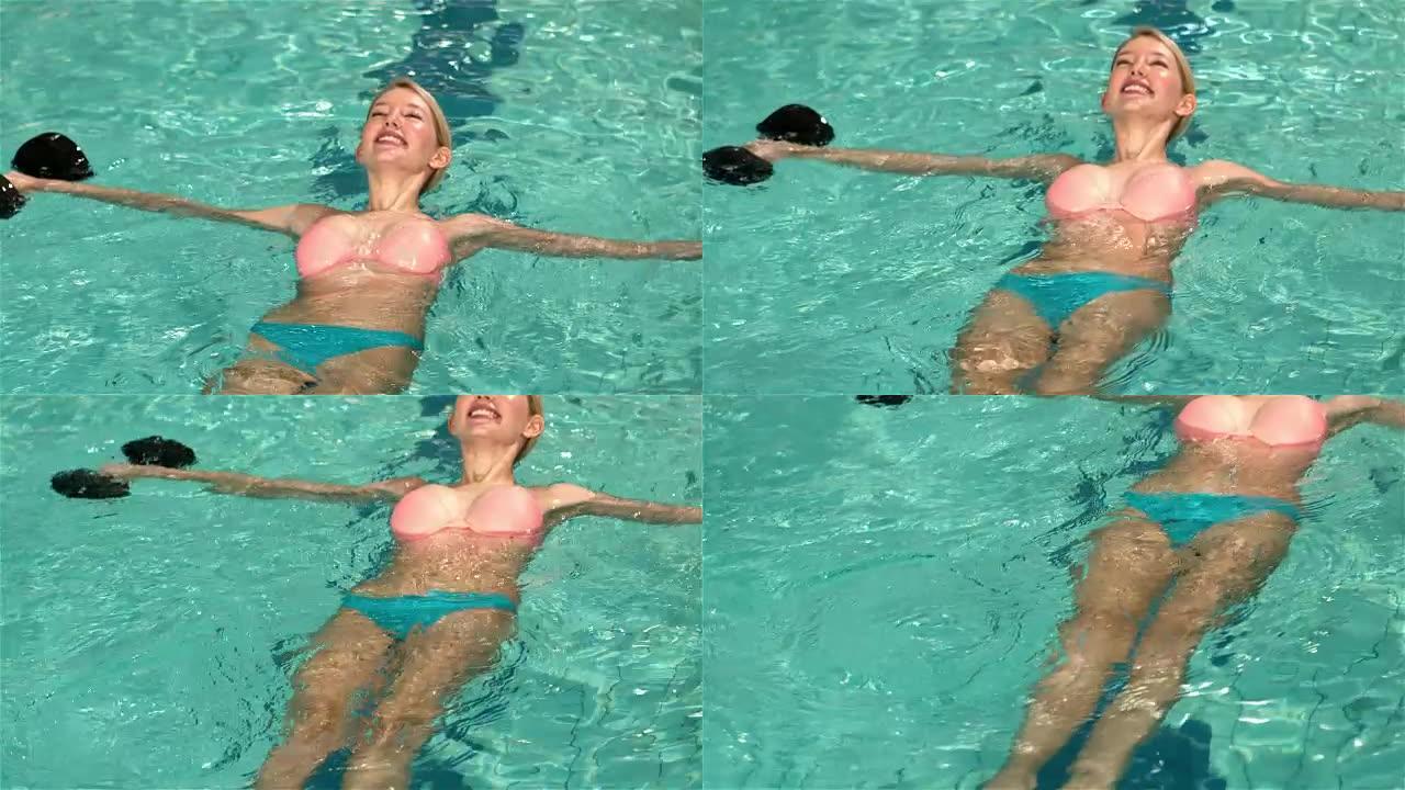 健康的女人在游泳池里放松