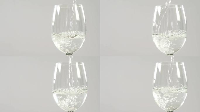 白葡萄酒落在白色背景下的玻璃杯中