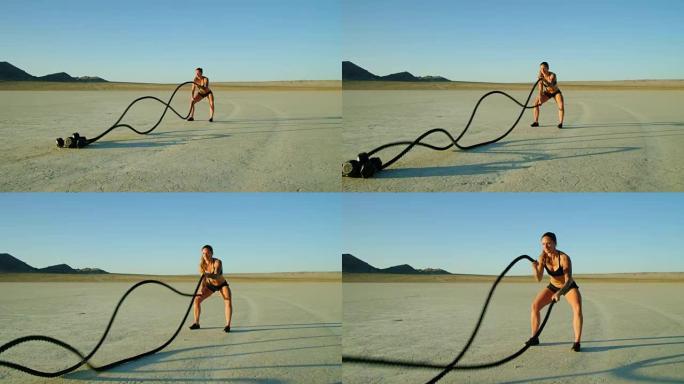慢动作运动女子在沙漠外面做极限战斗绳锻炼