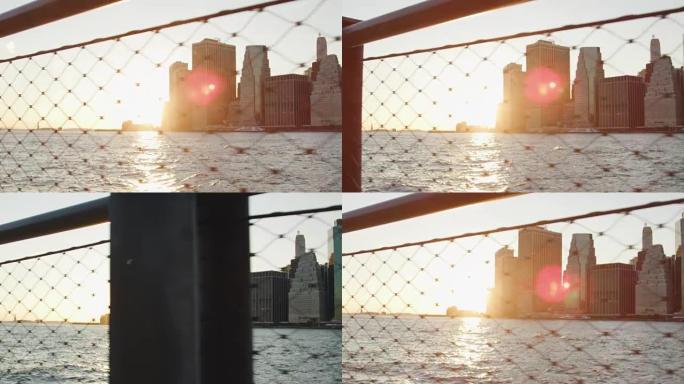 通过铁丝网观看日落时的曼哈顿天际线