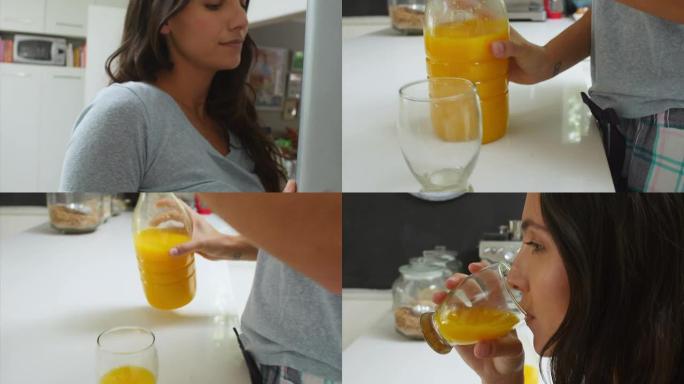 穿着睡衣的女人从冰箱里取橙汁