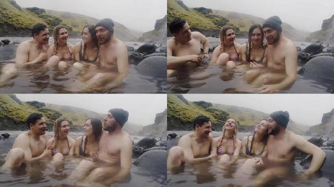 冰岛的温泉地热水疗中心。两对旅行夫妇在冰岛的热水池放松。享受沐浴的游客