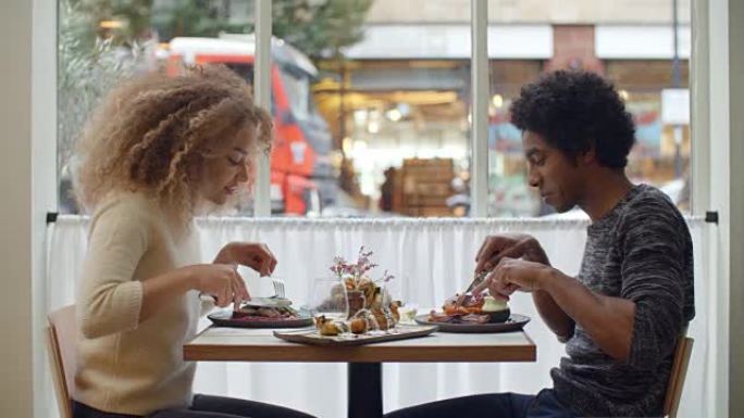 年轻夫妇在城市餐厅约会时用餐