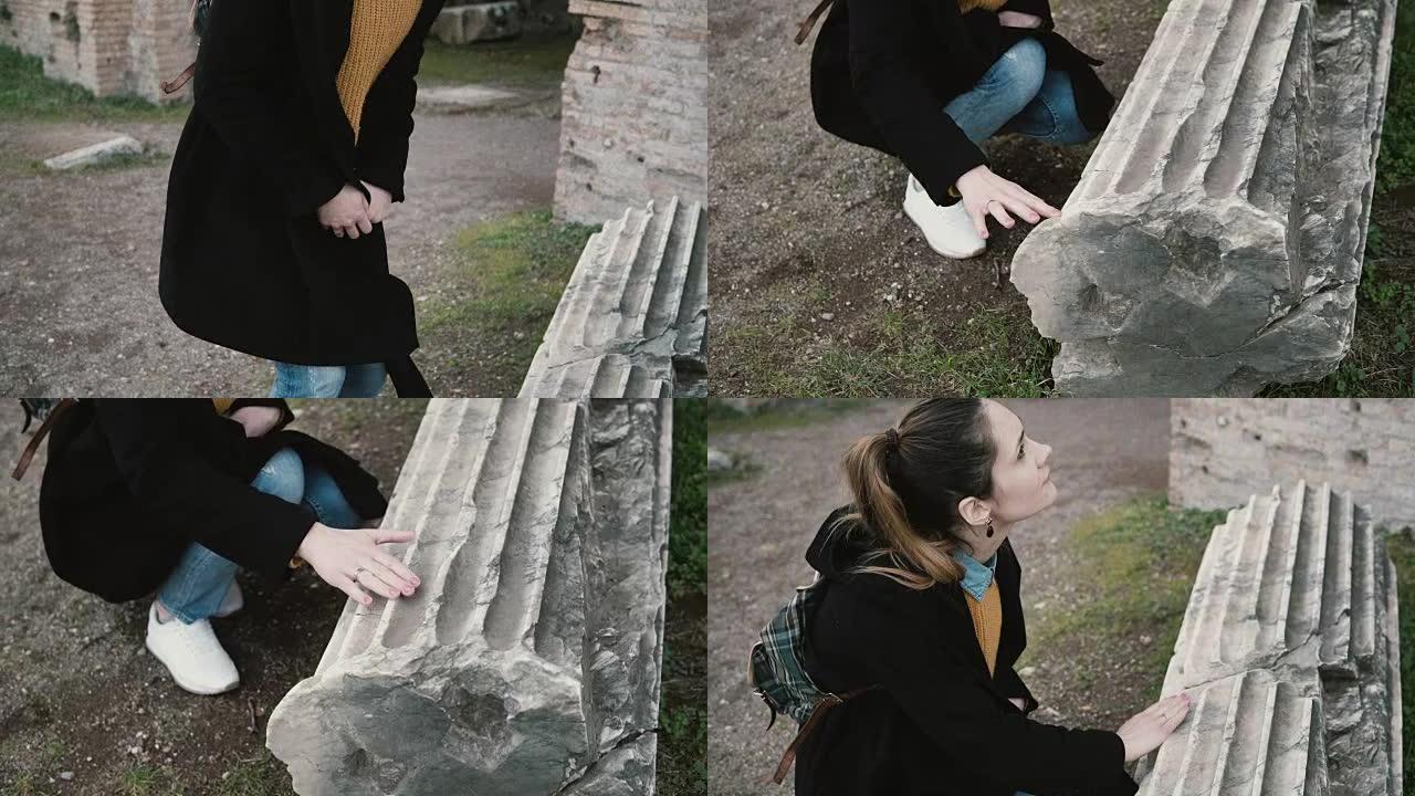 女人正在意大利罗马的一个古老城堡的院子里探索。女孩触摸古董和真实的柱子