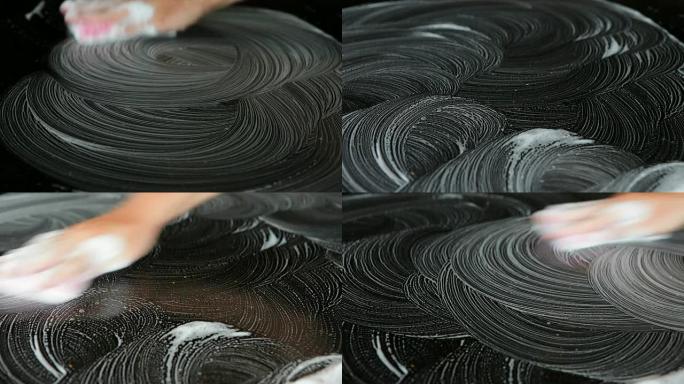 用海绵手工打磨黑色桌子的表面