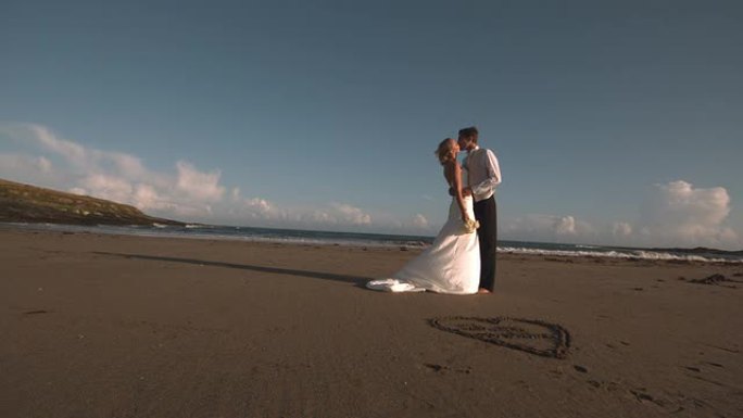 迷人的新娘夫妇在海滩上接吻