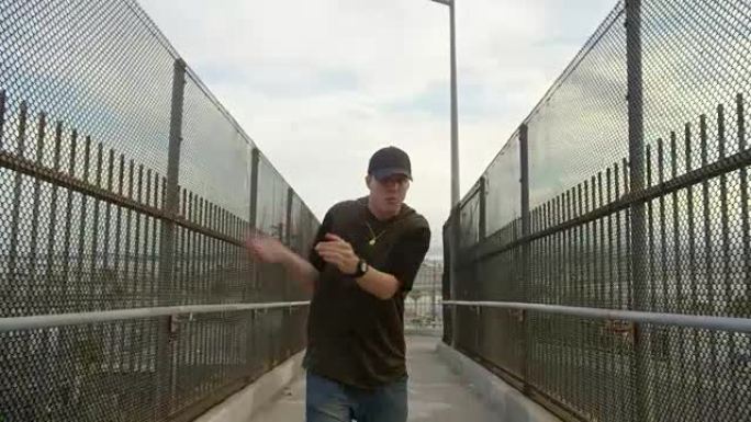男子自由式嘻哈在城市的高速公路立交桥上跳舞