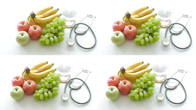 健康食品白色餐桌上的水果和听诊器背景健康概念