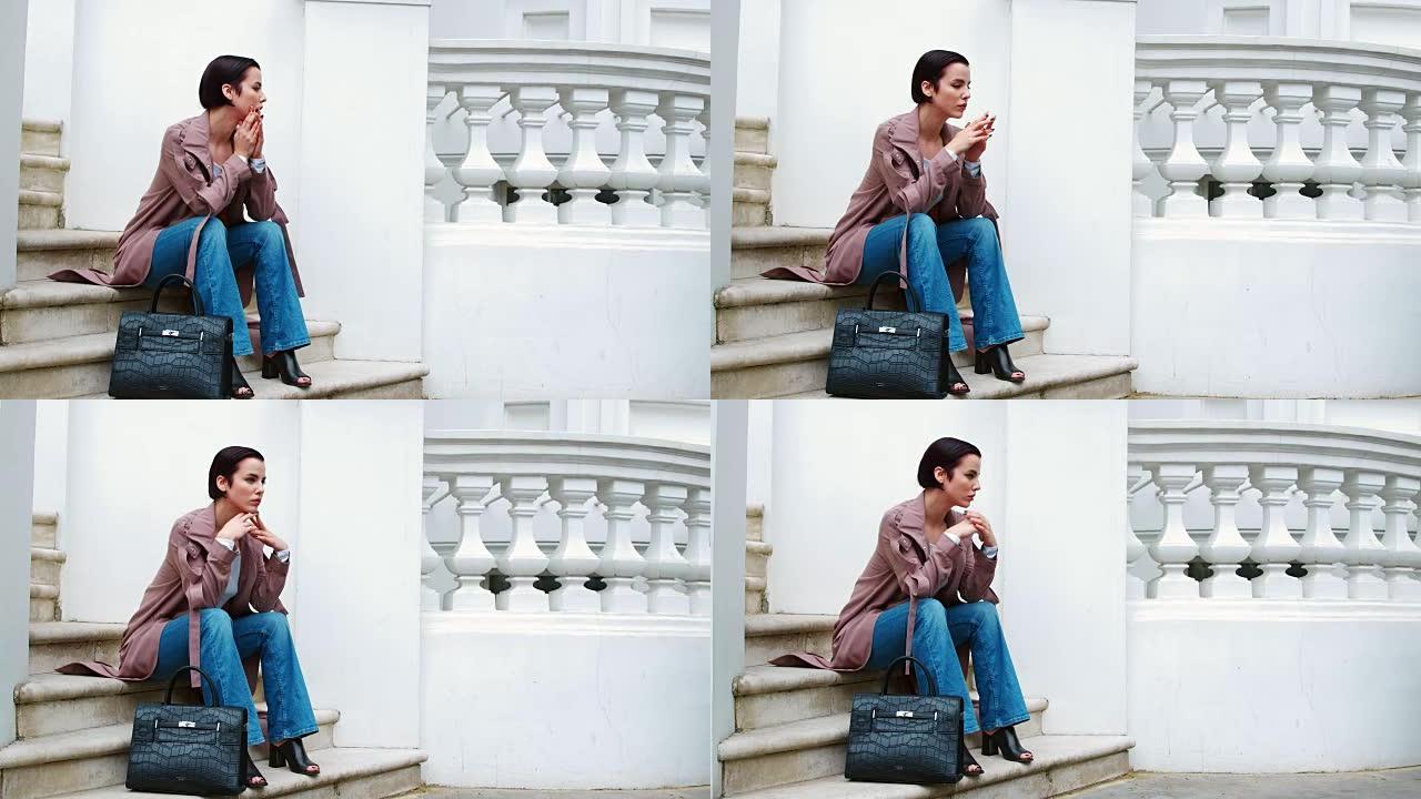 时尚意识强的年轻女子坐在城市建筑的台阶上