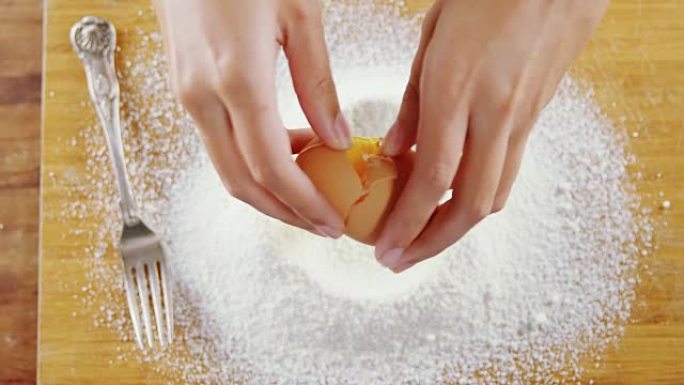 女人在木板上的面粉中打碎鸡蛋4k