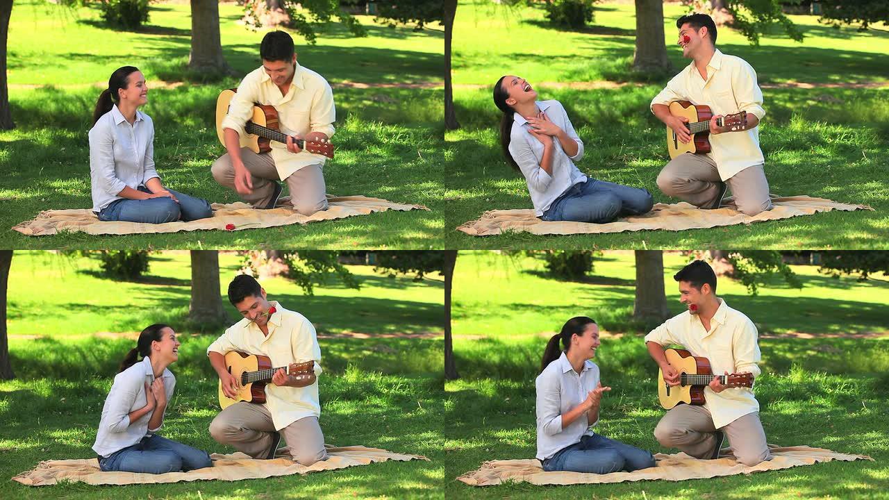 迷人的男人向妻子弹吉他