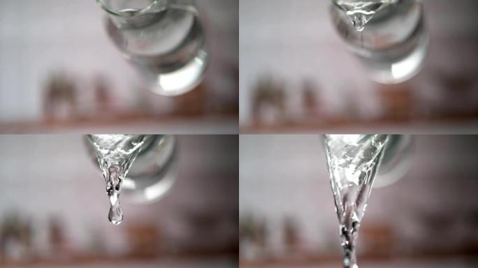 从透明的水罐中倒水。超级慢动作