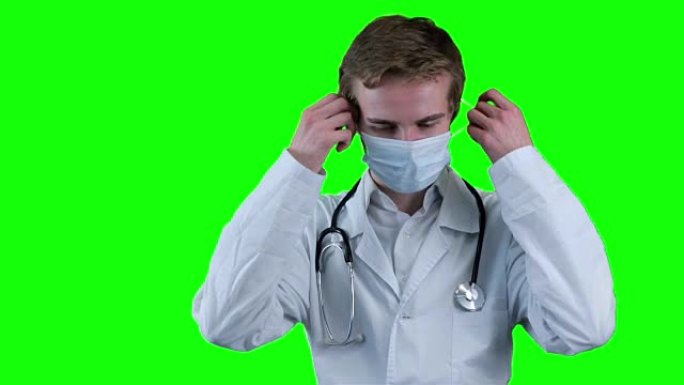 悲伤的医生取下医用口罩，看着屏幕。绿色屏幕，chromakey