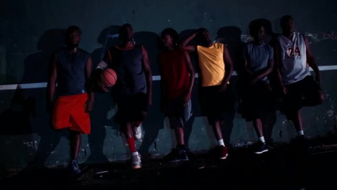 一群篮球运动员在球场墙上排队