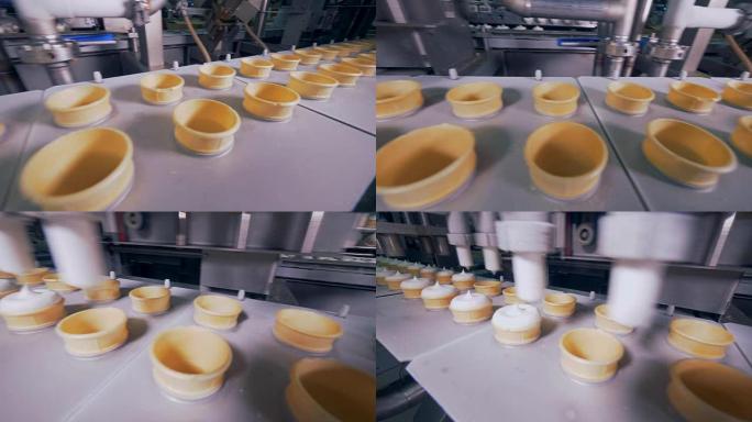 在productin生产线上用冰淇淋填充空的晶片锥。